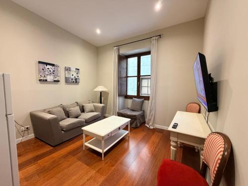 un soggiorno con un divano e un tavolo di Smartmonki Sinagoga Entre la Catedral y Zocodover a Toledo