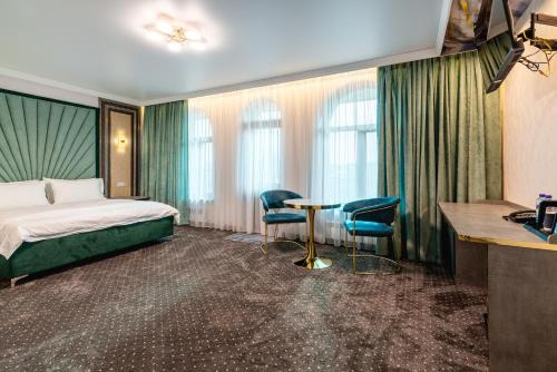 a hotel room with a bed and a table and chairs at РИМ Garden in Almaty