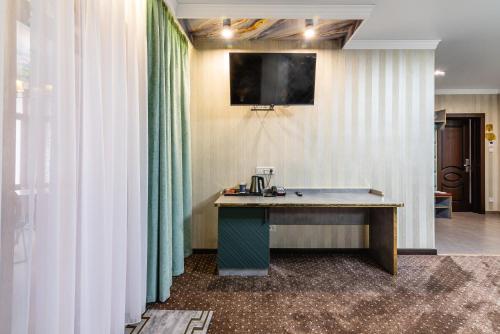 a desk in a room with green curtains at РИМ Garden in Almaty