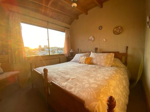 een slaapkamer met een bed met een groot raam bij Terraza CasaOcho in Viña del Mar