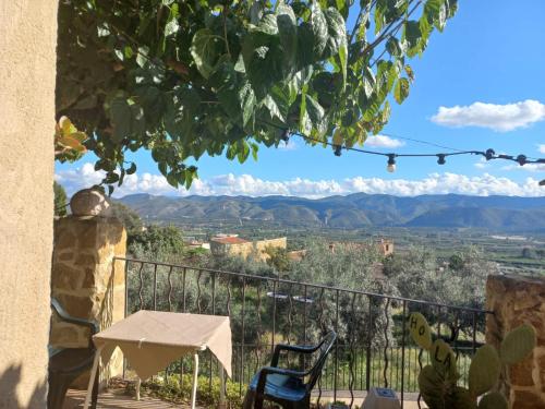 een tafel en stoelen op een balkon met uitzicht op de bergen bij CA TERESINA l RELAX RURAL in Montesa