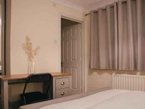a bedroom with a bed and a desk and a chair at Oxford sweet home in Oxford