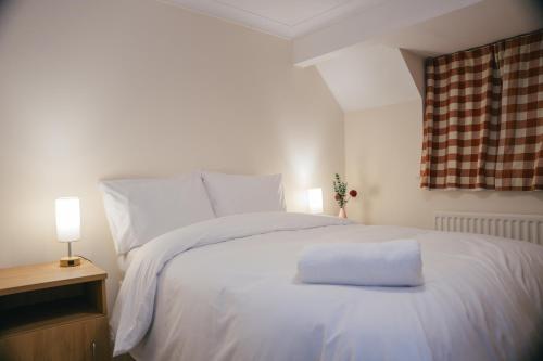a white bed with a white pillow on it at Oxford sweet home in Oxford