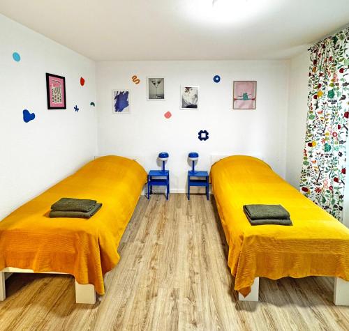 2 Betten in einem Zimmer mit gelben Decken in der Unterkunft Siegburg EG rechts in Siegburg