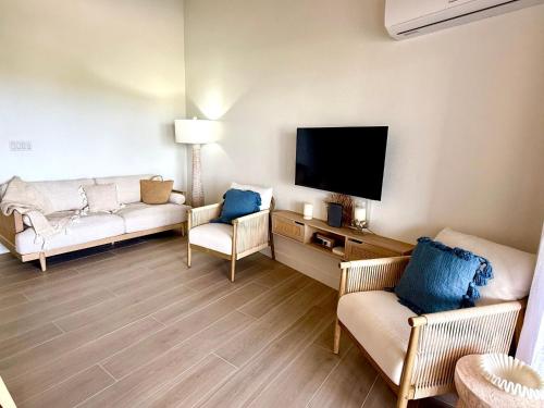 un soggiorno con due divani e una TV a schermo piatto di Lantana Sea La Vie - by ZenBreak a Saint James