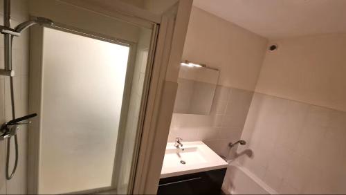 a white bathroom with a sink and a mirror at Magnifique T3 RDC vue mer-accès plage direct chez CATH in Trébeurden