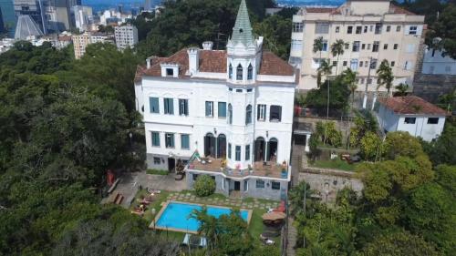 eine Luftaufnahme eines großen weißen Hauses mit Pool in der Unterkunft Castelo dos Tucanos Host in Rio de Janeiro