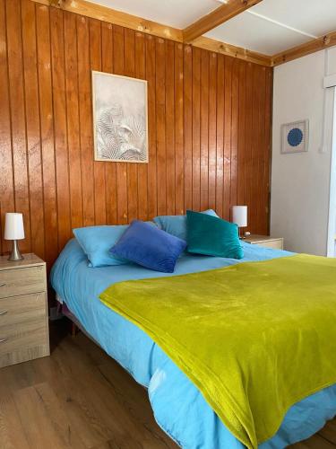 a bedroom with a bed with blue and green sheets at Loft Tongoy 3 Peninsula in Coquimbo
