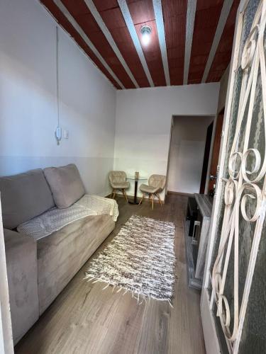 ein Wohnzimmer mit einer Couch und einem Teppich in der Unterkunft Kitnet mobiliado no Caiçara, de fácil acesso ao centro e shopping in Belo Horizonte
