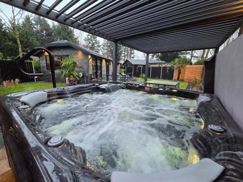 a hot tub with water in a backyard at Woodland Wellness Resort in Ermelo