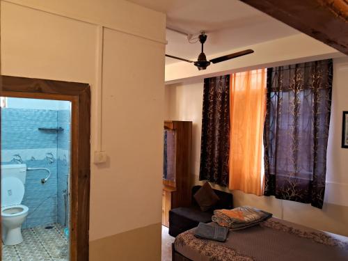 a room with a bathroom with a toilet and a window at Cupid's Heaven Resort in Agonda