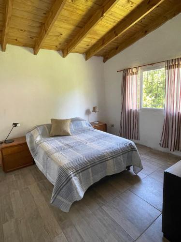 ein Schlafzimmer mit einem Bett und einem großen Fenster in der Unterkunft Casa de verano in Mar del Plata