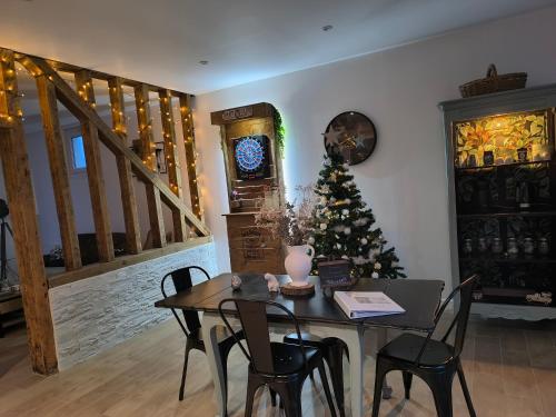 ein Esszimmer mit einem Tisch und einem Weihnachtsbaum in der Unterkunft L'Eucalyptus in Saint-Nicolas-dʼAliermont