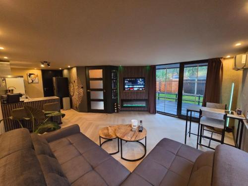a living room with a couch and a table at Woodland Wellness Resort in Ermelo
