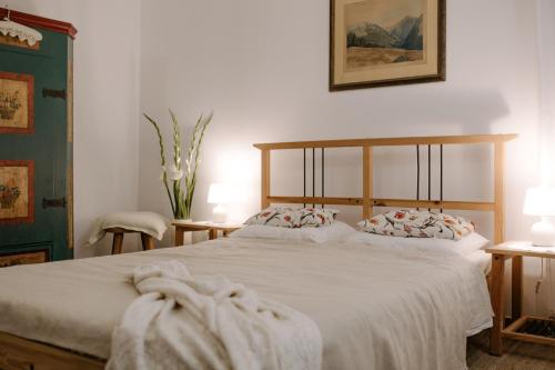 a bedroom with a large bed with white sheets at Willa Tyrolczyk in Karpacz