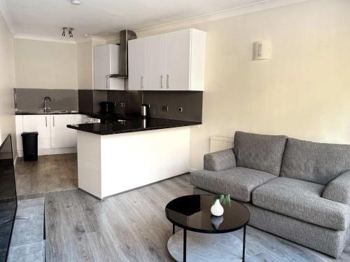 een woonkamer met een bank en een keuken bij York City Centre Flat with view - Best Location - Walk to Everything in York