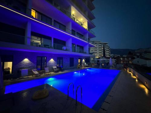 ein Schwimmbad vor einem Gebäude bei Nacht in der Unterkunft Elia Residence Rooms in Becici