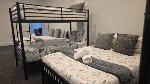 a room with three bunk beds and a mirror at Royal House by Bourne Hall in Bournemouth