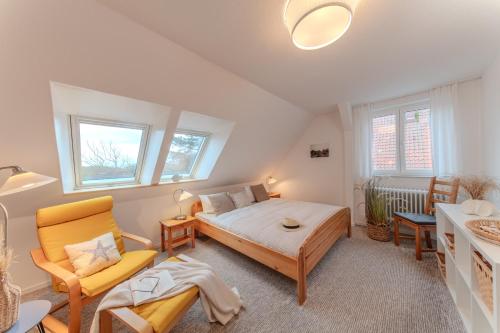 a bedroom with a bed and a couch and windows at Der Ferienhof am Meer in Fehmarn