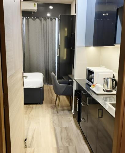 a small room with a kitchen and a microwave at Kaveri Studio Apartment near India Expo Centre in Greater Noida