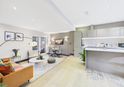 a kitchen and living room with a couch and a table at Stylish Mews House, Private Garden, Sleeps 4, Central Location in Twickenham