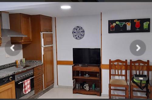 eine Küche mit einem Herd und einem TV an der Wand in der Unterkunft Casa da Tita 