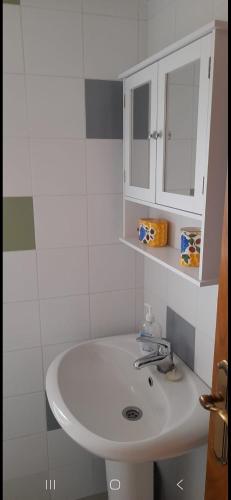 a bathroom with a white sink and a white cabinet at Casa da Tita in Peña de Folenche
