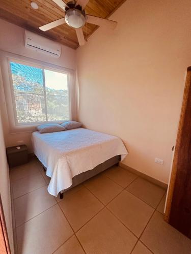 a small bedroom with a bed and a window at La Laguna in Nosara