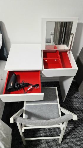 a white desk with a red drawer and a mirror at Airy flat is the heart of Northampton in Northampton
