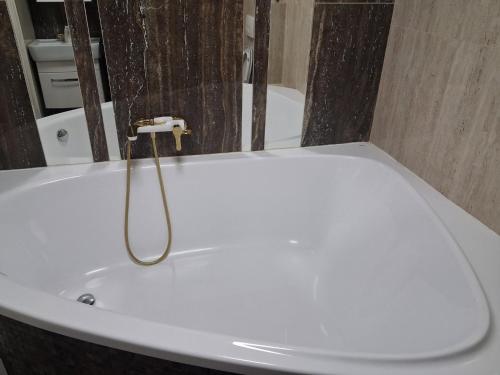 een wit bad met een kraan in de badkamer bij Галичанка Еліт SPA 