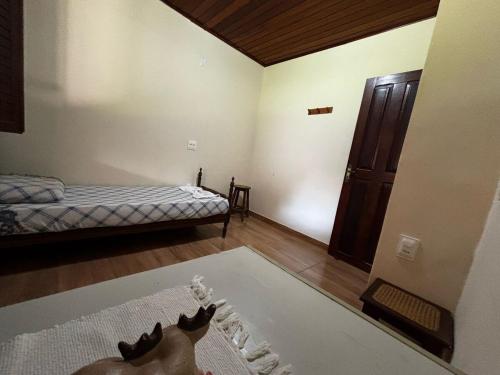a living room with a bed and a cat on a rug at Cantinho da Serra do Cipó in Santana do Riacho