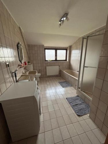 a bathroom with a tub and a sink and a shower at Ferienwohnung Gaber in Reichshof 