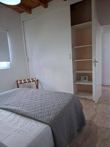een slaapkamer met een bed en een open kast bij Vista Malbec 2 in Ciudad Lujan de Cuyo