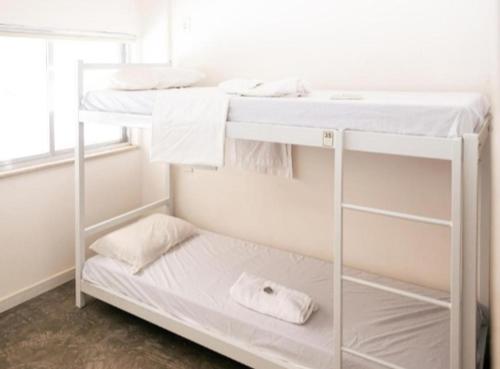 a white bunk bed in a room with a window at Secreto Quartos in Rio de Janeiro