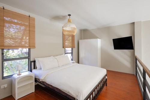 een slaapkamer met een wit bed en een tv bij Aqua Luxe in Srithanu