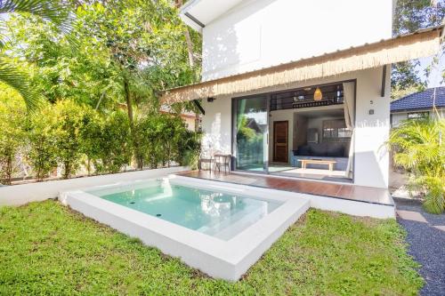 een zwembad in de achtertuin van een huis bij Aqua Luxe in Srithanu