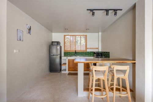 eine Küche mit einem Holztisch und Stühlen in der Unterkunft Aqua Luxe in Srithanu