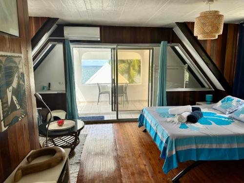 een slaapkamer met een bed en uitzicht op de oceaan bij Okilei House in Taputapuapea