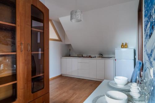 a kitchen with white cabinets and a refrigerator at Willa Dukat in Czarny Dunajec