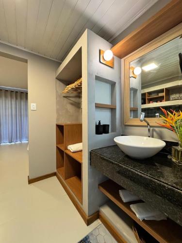a bathroom with a sink and a large mirror at KORA MAR - Taipu de Fora - BA in Barra Grande