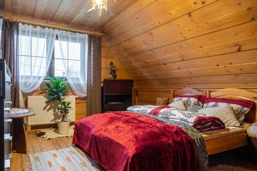 a bedroom with a wooden ceiling with a bed at Willa Dukat in Czarny Dunajec