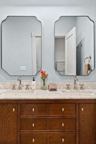 a bathroom with two sinks and two mirrors at The Optimist Guesthouse | 2 in Camden
