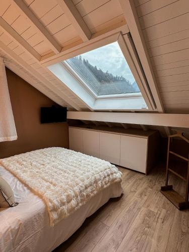 a bedroom with a bed with a large window at Triplex Léonie - Standing and Comfort - 3 étoiles in Cluses