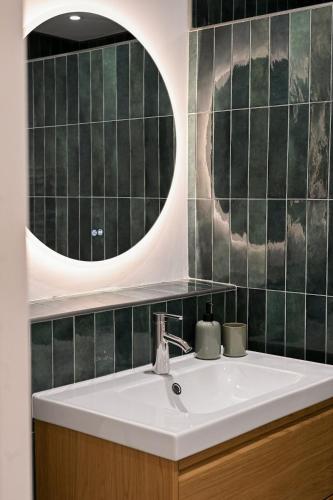 a bathroom with a sink and a mirror at Triplex Léonie - Standing and Comfort - 3 étoiles in Cluses