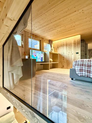 a room with a glass wall in a house at Mulini 22 - Eco Suite & Spa in Temù