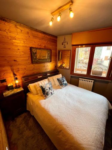 a bedroom with a bed in a room with wooden walls at The Mountain Escape - Luxury Apartment in Prato Nevoso