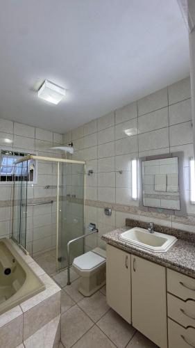 een badkamer met een toilet, een wastafel en een douche bij Refúgio na Lagoa in Florianópolis
