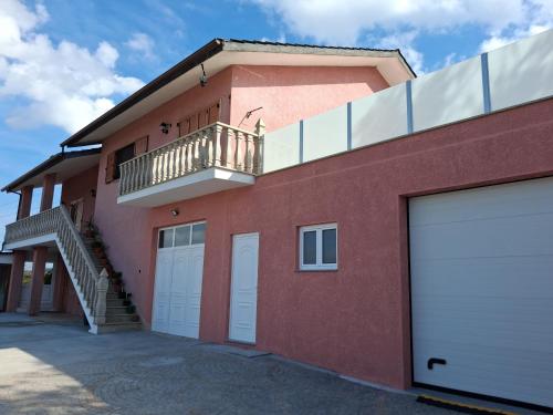ein rotes Backsteinhaus mit Balkon und weißen Garagentoren in der Unterkunft Casa Rosàlia in Castro Daire