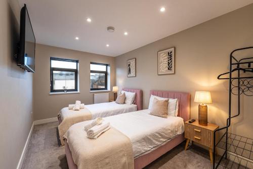 twee bedden in een kamer met een tv en twee ramen bij Bright 2BR Flat, Central Chatham, Parking in Chatham