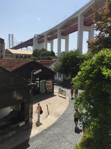 a group of people walking down a street under a bridge at LX Factory Apartment 1 in Lisbon